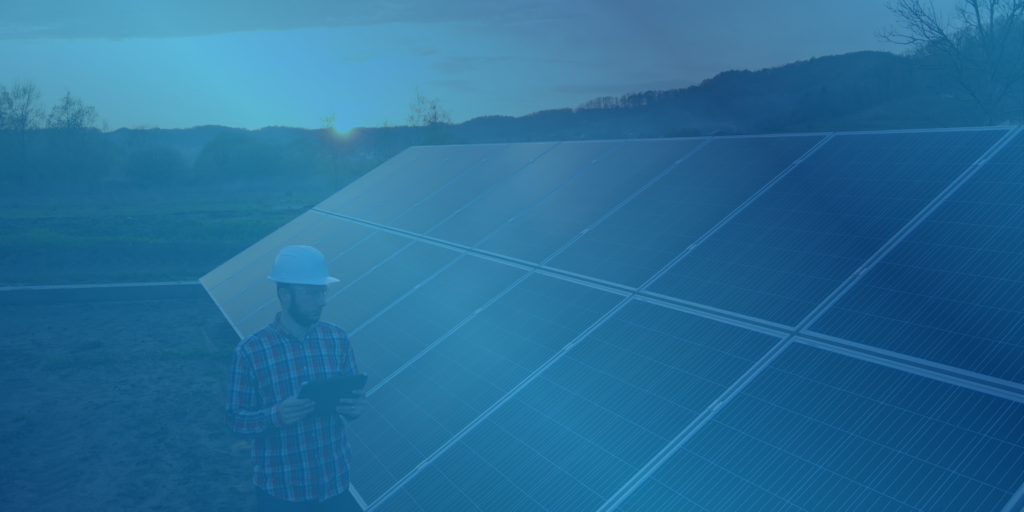 Person in hard hat monitoring a solar panel array