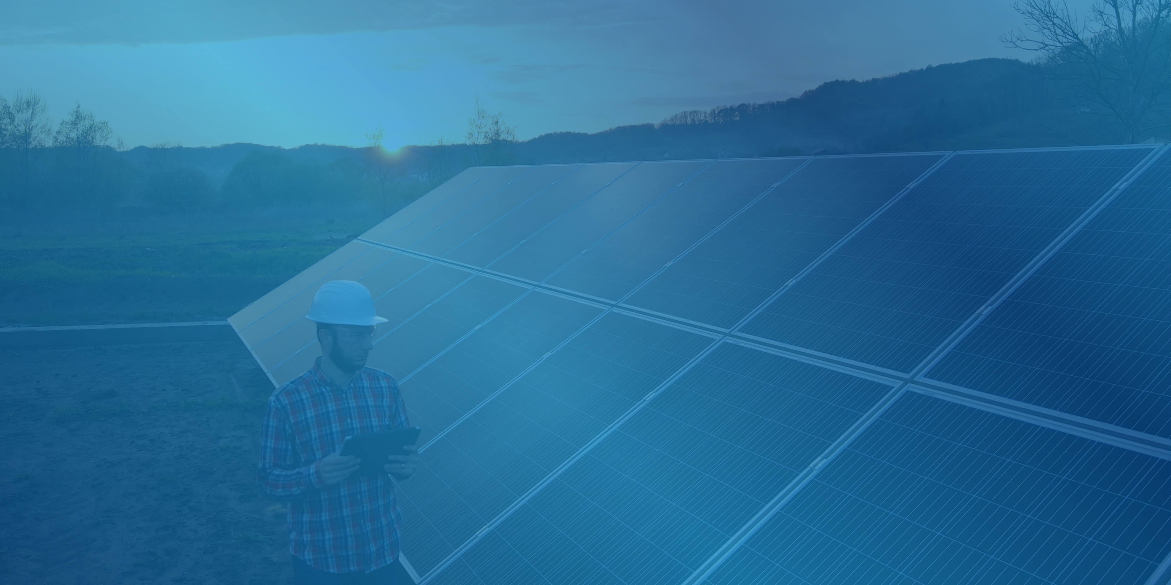 Person in hard hat monitoring a solar panel array
